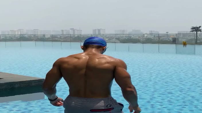 A rear view of the figure at the pool edge.